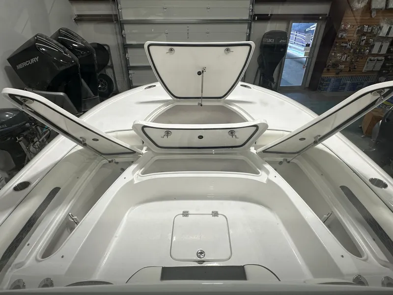 Slide: The Image of 2025 Tidewater 2500CB boat interior with open storage compartments in a showroom. - 24