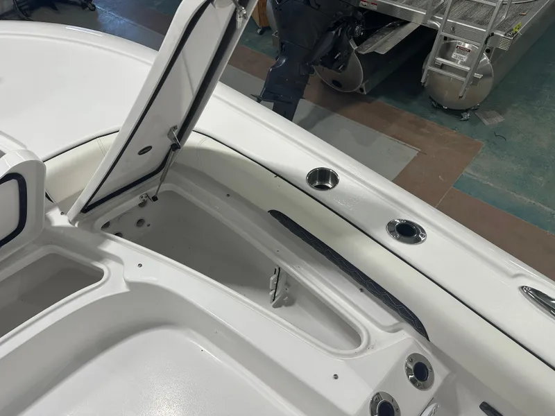 Slide: The Image of 2025 Tidewater 2500CB boat interior with open storage compartments and cup holders. - 26