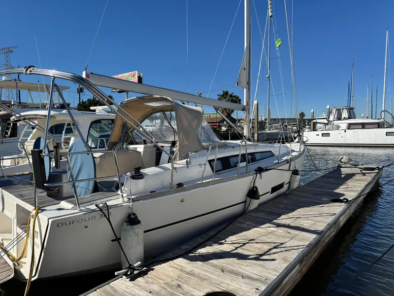 The Image of 2021 Dufour 360 sailboat docked at marina under clear blue sky. - 0