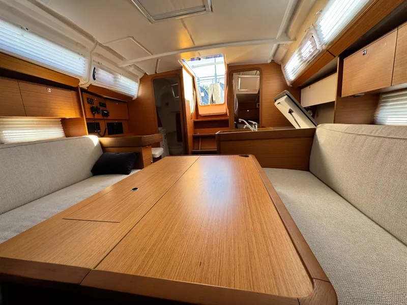 Slide: The Image of Interior of 2021 Dufour 360 sailboat with wooden table and cozy seating. - 10