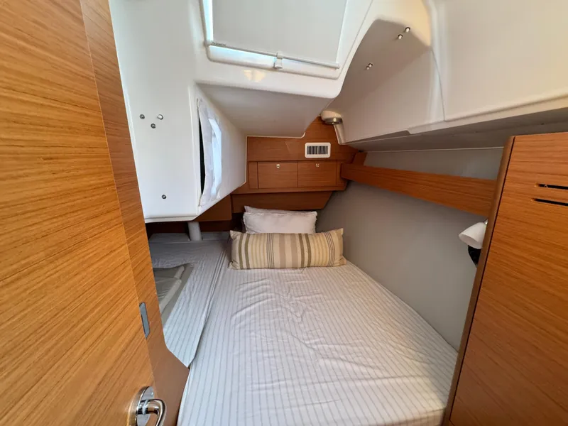 Slide: The Image of Cozy cabin interior of 2021 Dufour 360 sailboat with wooden accents and bedding. - 15