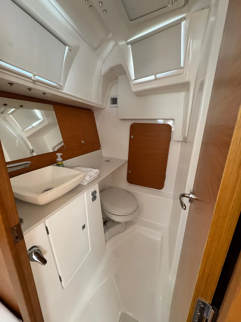Slide: The Image of 2021 Dufour 360 yacht bathroom with modern fixtures and wood accents. - 7