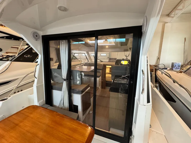 Slide: The Image of 2022 Beneteau Antares 9 cabin interior with gray cushions and modern design. - 15