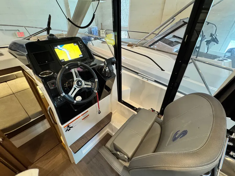 Slide: The Image of 2022 Beneteau Antares 9 interior with wooden table and gray seating. - 16