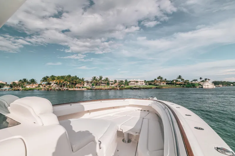 Slide: The Image of 2021 HCB 42 Lujo yacht cruising near a scenic coastal area under a partly cloudy sky. - 7