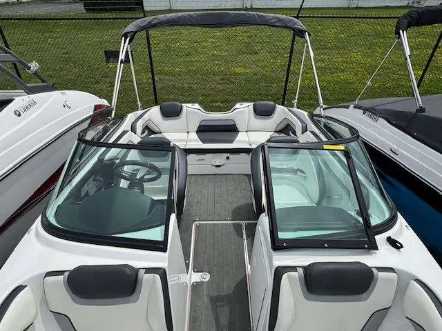 Slide: The Image of 2017 Yamaha Boats SX195 with sleek interior and dual windshields, docked outdoors. - 10