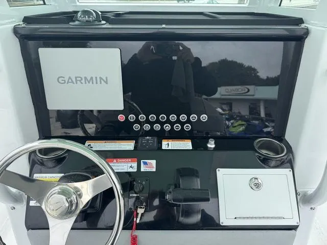 Slide: The Image of 2025 Wellcraft 223 Fisherman dashboard with Garmin navigation system and steering wheel. - 11