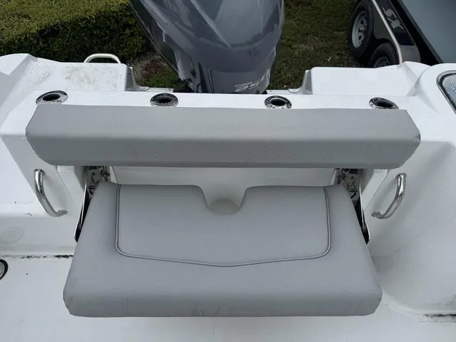 Slide: The Image of 2025 Wellcraft 223 Fisherman boat seat with rod holders and engine in background. - 8