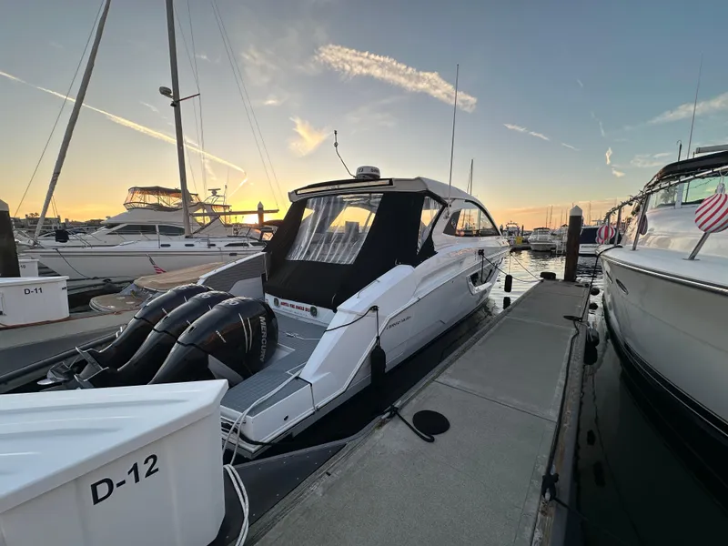 Slide: The Image of 2021 Cruisers Yachts 42 GLS OB docked at sunset, featuring twin Mercury outboards. - 14