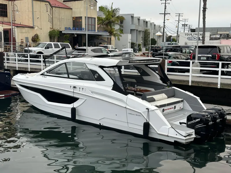 Slide: The Image of 2021 Cruisers Yachts 42 GLS OB docked, featuring sleek design and powerful Mercury outboard engines. - 19