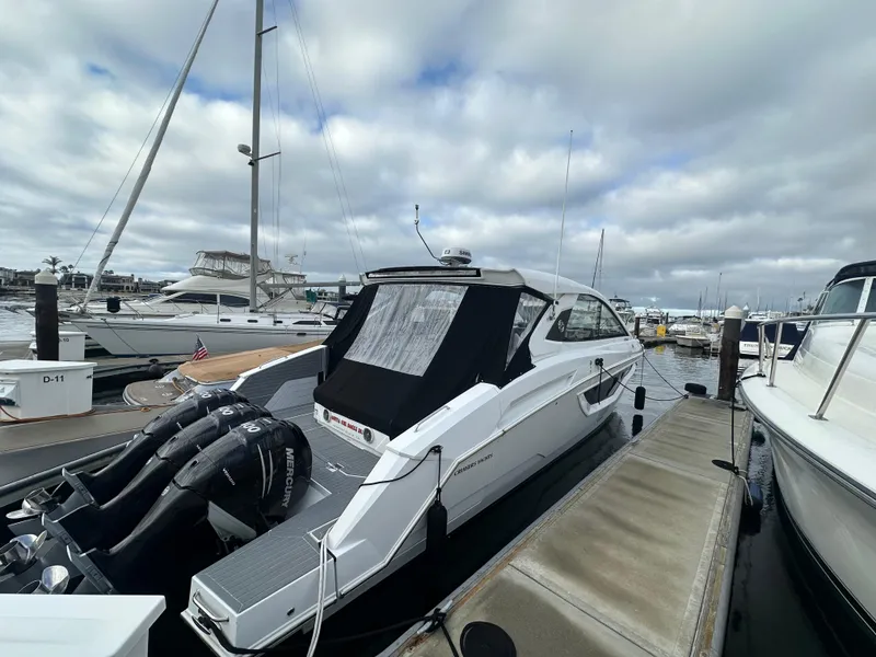 Slide: The Image of 2021 Cruisers Yachts 42 GLS OB docked at marina, featuring triple Mercury outboard engines. - 34