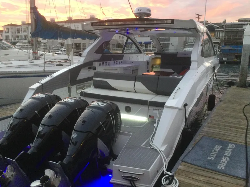 Slide: The Image of 2021 Cruisers Yachts 42 GLS OB docked at sunset with triple outboard engines. - 42