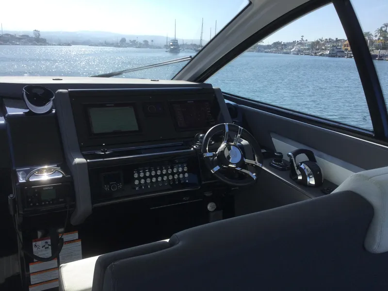 Slide: The Image of 2021 Cruisers Yachts 42 GLS OB helm with modern controls and scenic water view. - 54