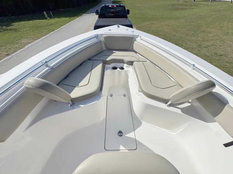 Slide: The Image of 2023 Key West 239 FS boat interior with beige seating, parked on grass. - 10