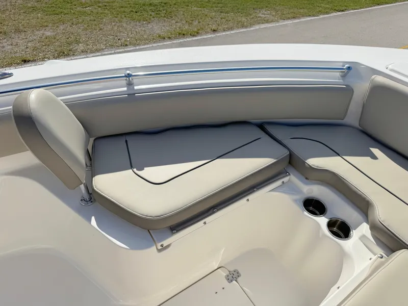 Slide: The Image of 2023 Key West 239 FS boat interior with cushioned seating and cup holders. - 12