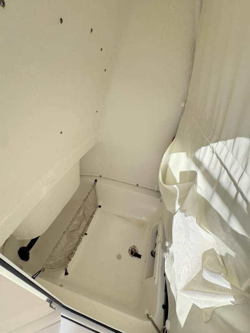 Slide: The Image of 2023 Key West 239 FS boat interior storage compartment with netting and curtain. - 17