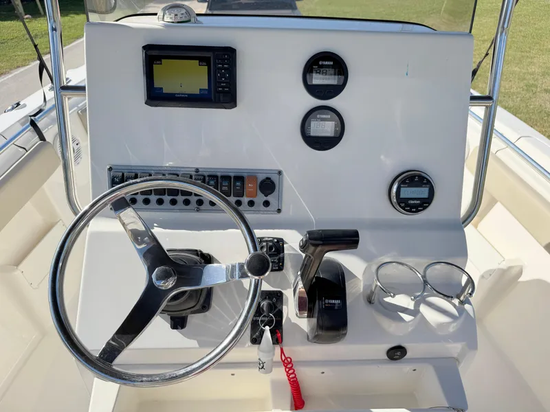 Slide: The Image of 2023 Key West 239 FS boat dashboard with steering wheel and navigation controls. - 21