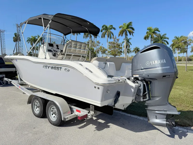 Slide: The Image of 2023 Key West 239 FS boat on trailer with Yamaha engine, palm trees in background. - 3