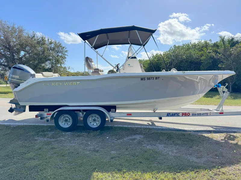 Slide: The Image of 2023 Key West 239 FS boat on trailer, parked outdoors under clear sky. - 6