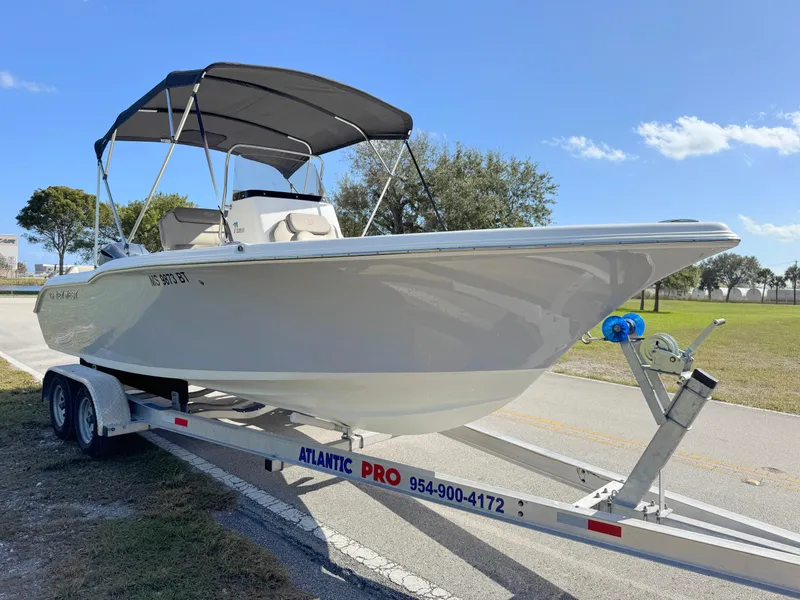 Slide: The Image of 2023 Key West 239 FS boat on trailer under clear blue sky. - 7
