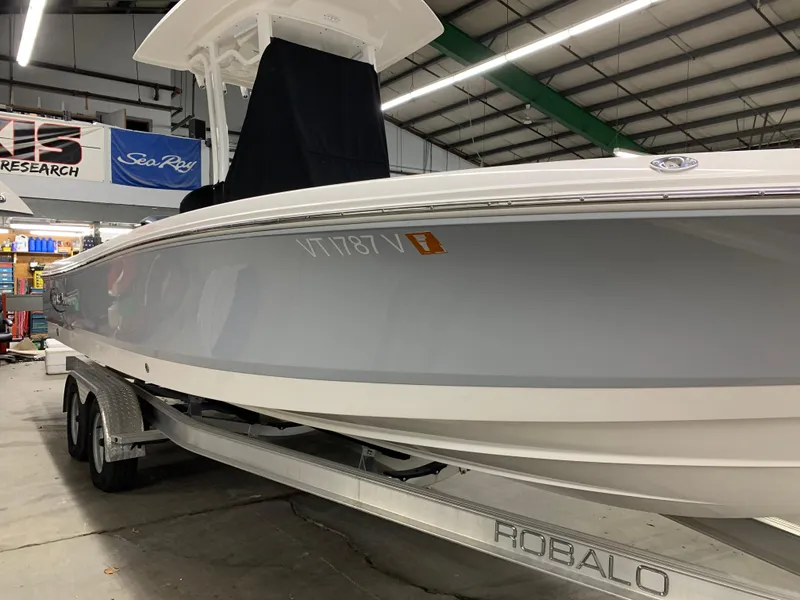Slide: The Image of 2019 Robalo 246 Cayman boat on trailer in indoor showroom. - 11