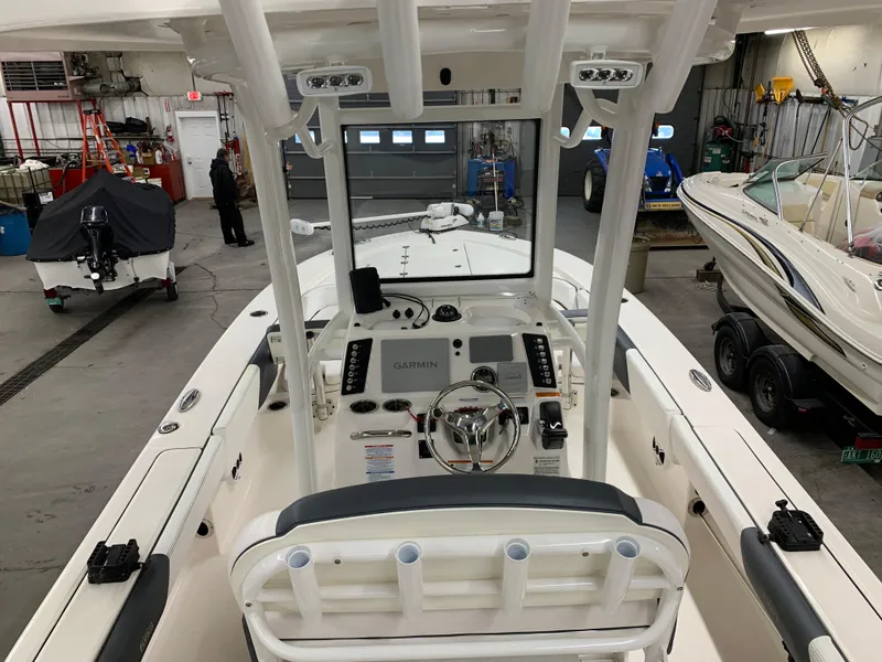 Slide: The Image of 2019 Robalo 246 Cayman boat interior with steering console in a garage setting. - 12