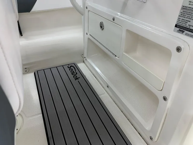 Slide: The Image of 2019 Robalo 246 Cayman boat interior with SeaDek flooring and storage compartments. - 26