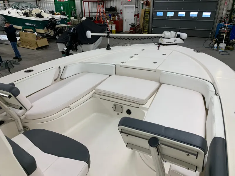 Slide: The Image of 2019 Robalo 246 Cayman boat interior with cushioned seating in a workshop. - 27