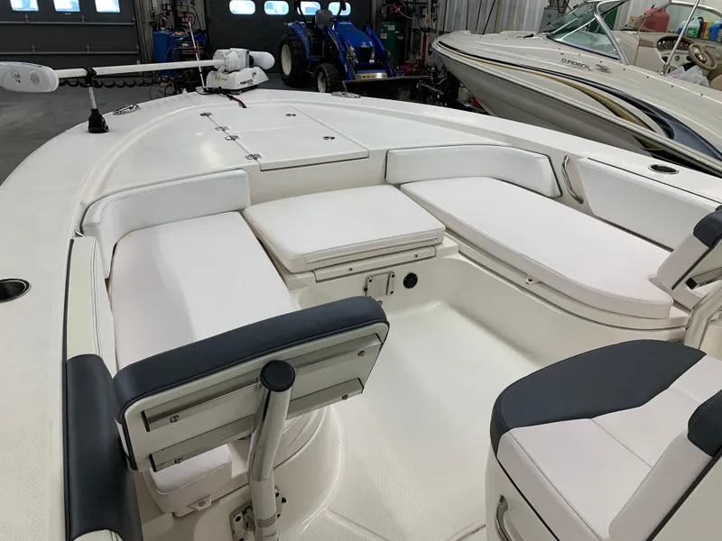 Slide: The Image of 2019 Robalo 246 Cayman boat interior with white seating and storage compartments. - 28
