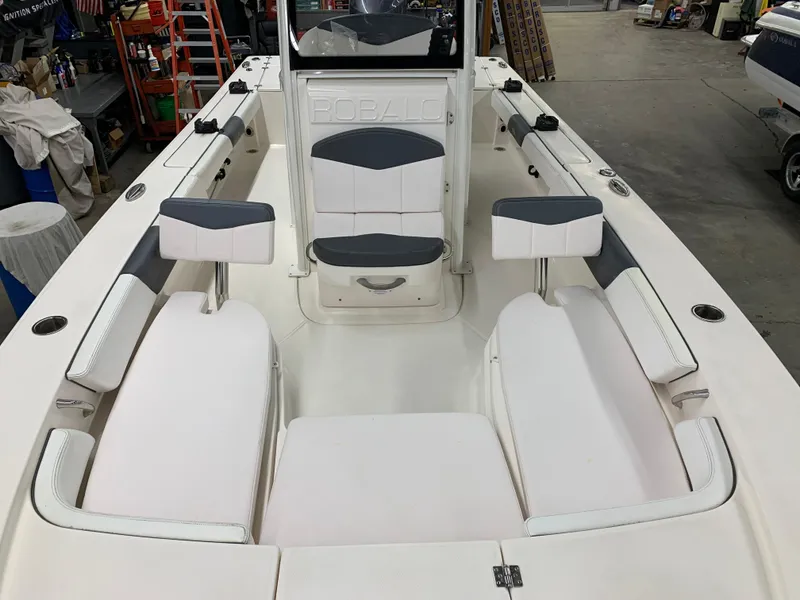 Slide: The Image of 2019 Robalo 246 Cayman boat interior with white seating in a workshop setting. - 33