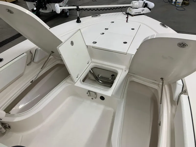 Slide: The Image of 2019 Robalo 246 Cayman boat with open storage compartments and clean white interior. - 35