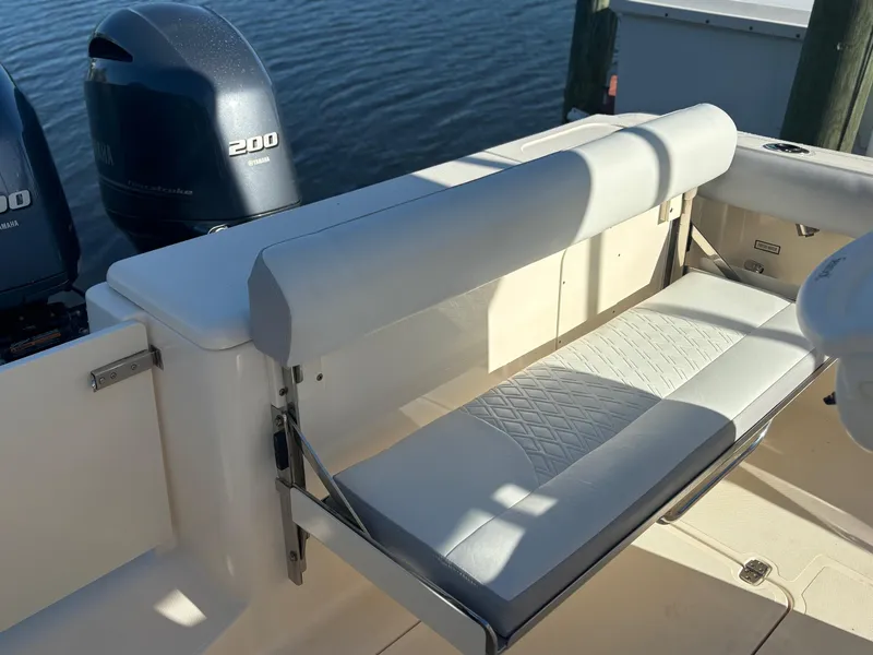Slide: The Image of 2014 Pursuit C 260 Center Console boat with cushioned seating and twin 200 horsepower engines. - 22