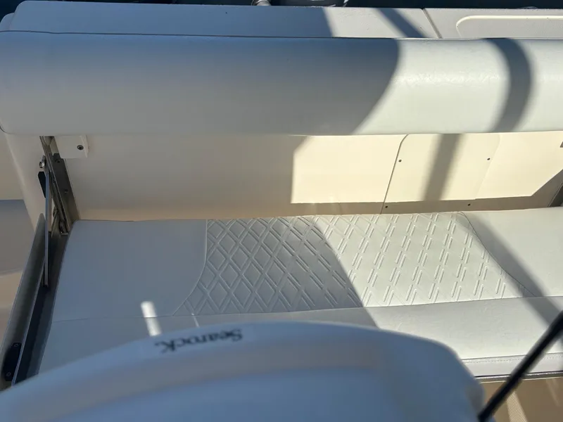Slide: The Image of 2014 Pursuit C 260 Center Console boat seat with white upholstery and sunlight shadows. - 24