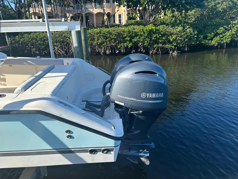 Slide: The Image of 2014 Pursuit C 260 Center Console boat with Yamaha outboard engines docked by the water. - 4