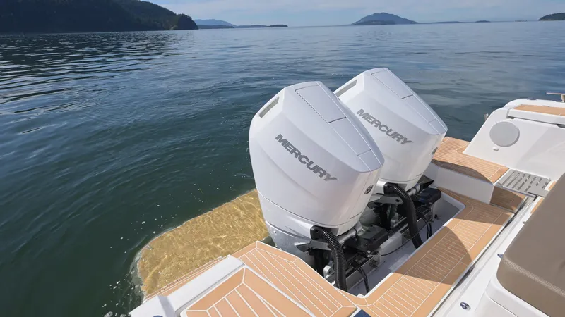 Slide: The Image of Twin Mercury outboard engines on a 2025 Nimbus W11 boat, cruising on a serene lake. - 12