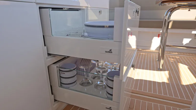 Slide: The Image of Modern kitchen drawers with glassware and dishes in a 2025 Nimbus W11 yacht. - 17