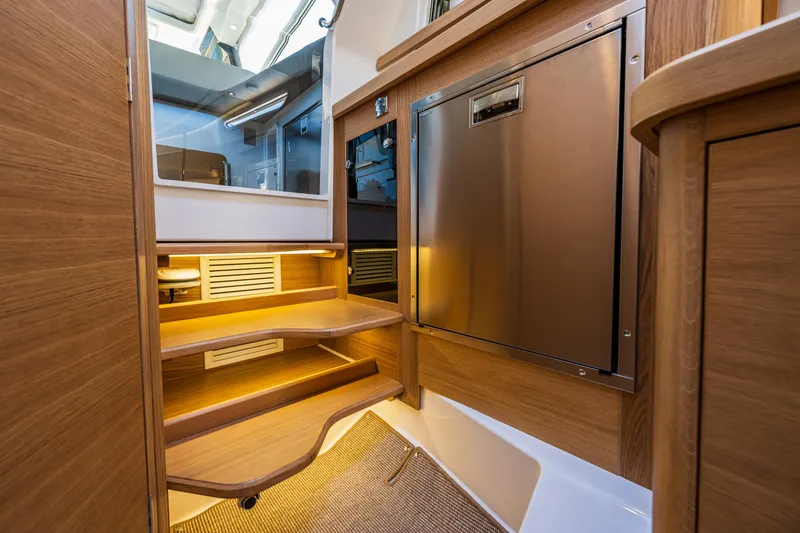 Slide: The Image of Luxurious interior of 2025 Nimbus W11 yacht with wooden steps and stainless steel appliances. - 22