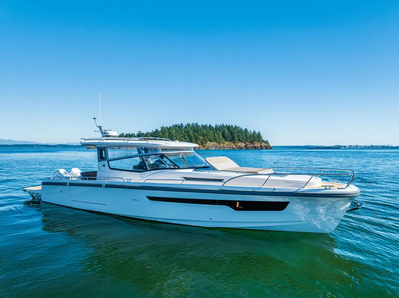 Slide: The Image of 2025 Nimbus W11 boat cruising on a sunny day, surrounded by scenic water and forested hills. - 3
