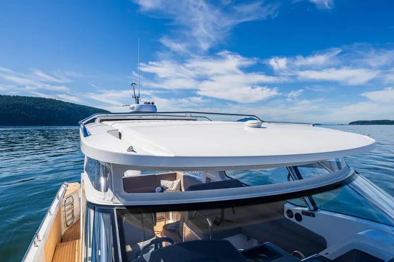 Slide: The Image of Nimbus W11 2025 yacht cruising on a serene lake under a clear blue sky. - 31
