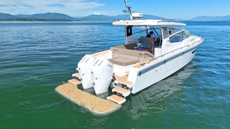 Slide: The Image of 2025 Nimbus W11 boat cruising on a serene lake with scenic mountain backdrop. - 6