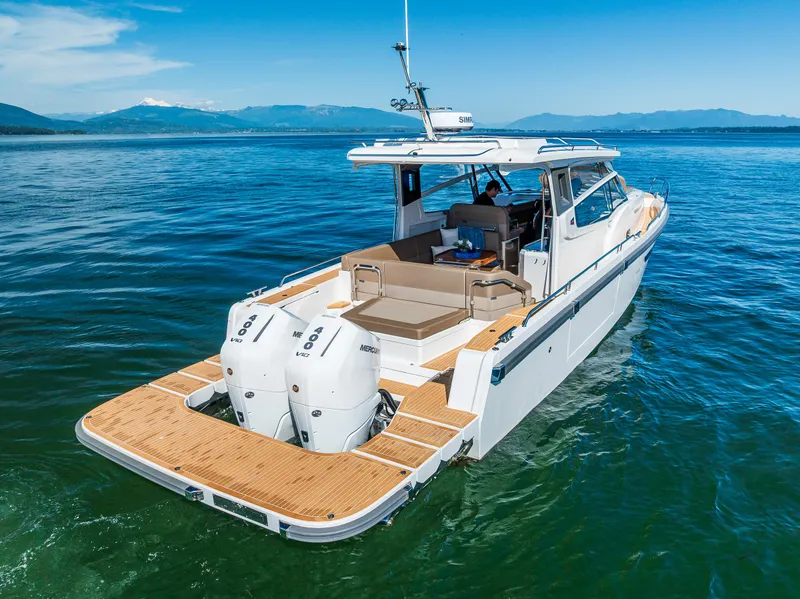 Slide: The Image of Nimbus W11 2025 motorboat cruising on clear blue water with scenic mountain backdrop. - 8