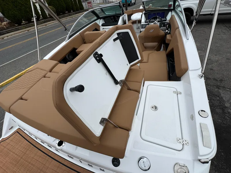 Slide: The Image of 2025 Four Winns H2 OB boat interior with tan seating and storage compartments. - 11