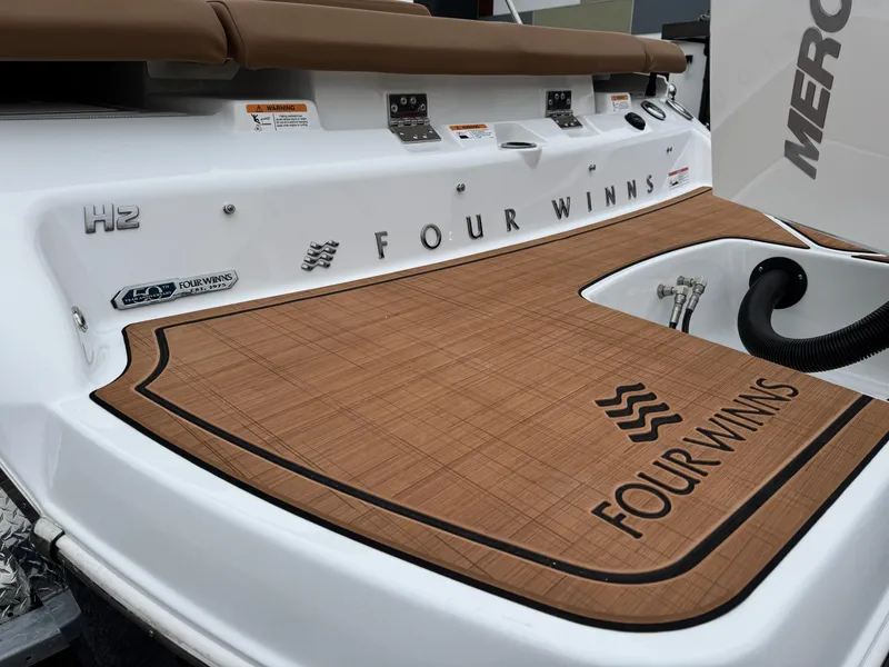 Slide: The Image of 2025 Four Winns H2 OB boat deck with logo and teak-style flooring. - 27
