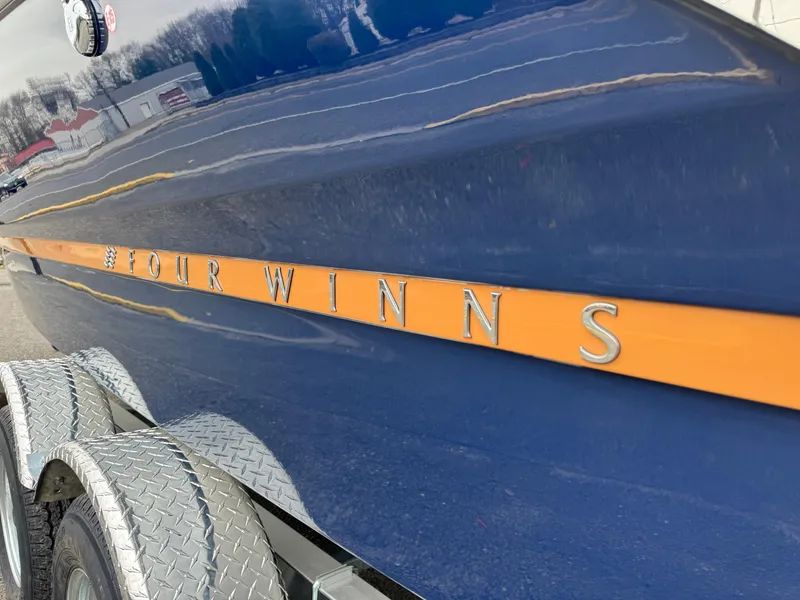 Slide: The Image of 2025 Four Winns H2 OB boat with blue and orange detailing on a trailer. - 29