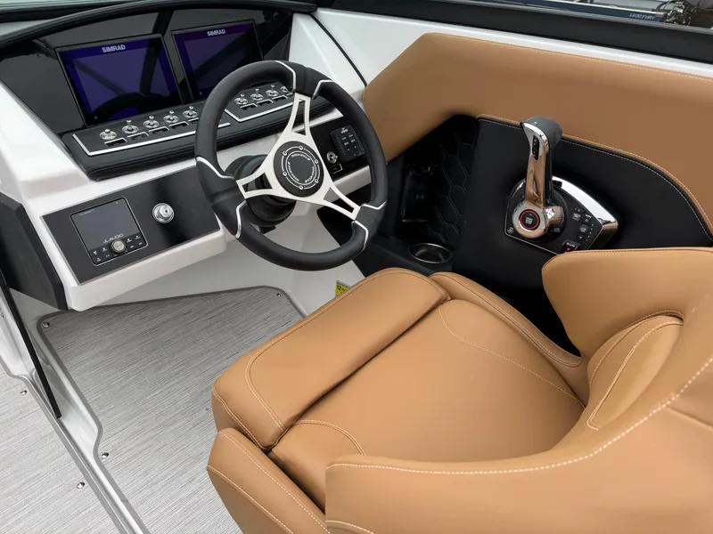 Slide: The Image of 2025 Four Winns H2 OB boat cockpit with tan leather seat and modern controls. - 4