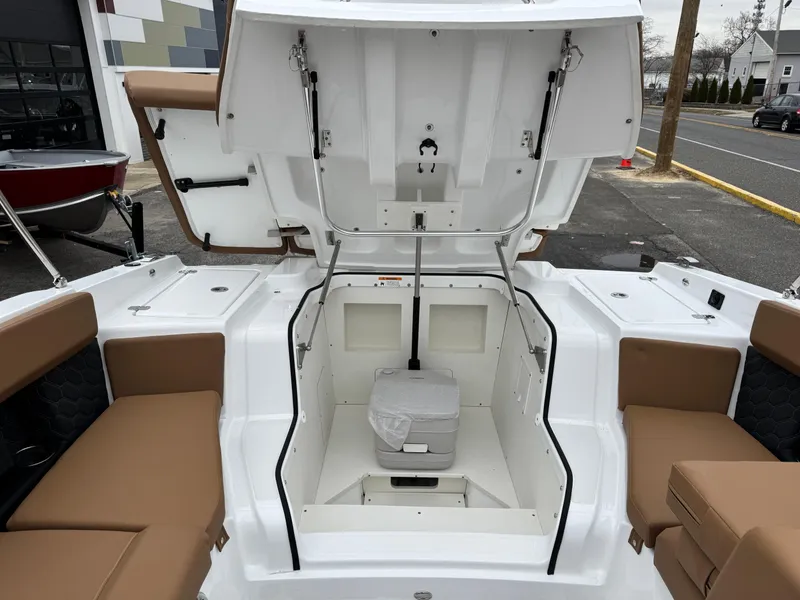 Slide: The Image of 2025 Four Winns H2 OB boat interior with open storage compartment and seating. - 7