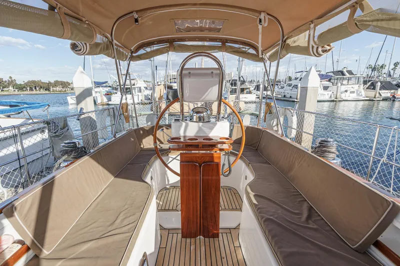 Slide: The Image of Spacious cockpit of 2012 Hylas 46 yacht with wooden accents and marina view. - 14