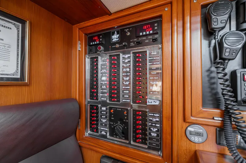 Slide: The Image of Electrical control panel on a 2012 Hylas 46 yacht, featuring switches and communication devices. - 26