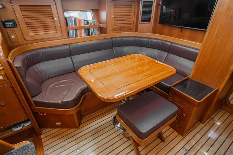 Slide: The Image of Luxurious 2012 Hylas 46 yacht interior with wooden dining area and leather seating. - 31