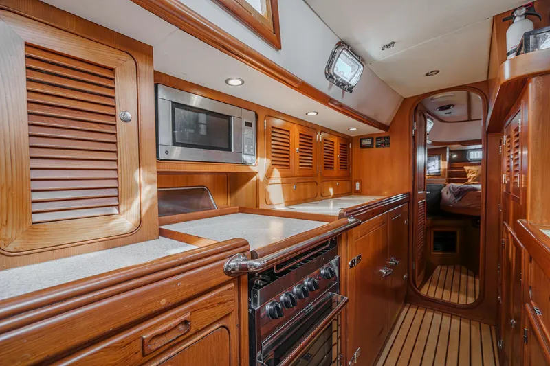 Slide: The Image of Luxurious 2012 Hylas 46 yacht interior with wooden cabinetry and modern kitchen amenities. - 32